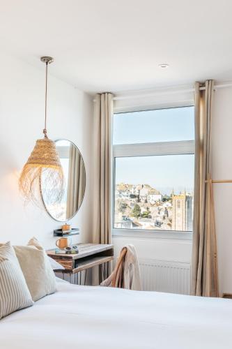 a bedroom with a bed and a large window at Harbour View House in St Ives