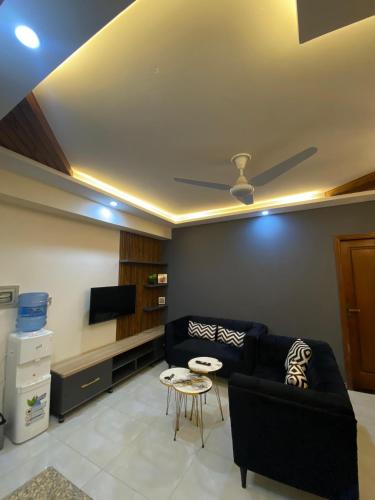 a living room with a couch and a tv at Luxury, Modern & Central Apartment Islamabad, with Gym, Near Motorway & Airport in Islamabad