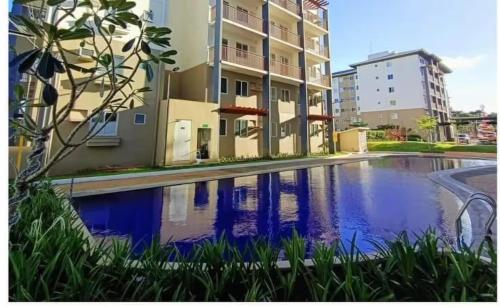a swimming pool in front of a building at AA Cozy Comfort in Nuvali in Calamba