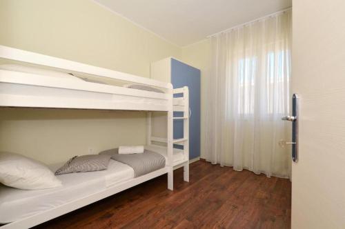 a bedroom with two bunk beds and a window at D&N Apartment in Kaštela