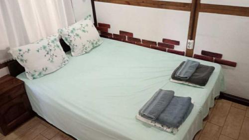 a bed with two towels sitting on top of it at The Green Line house in Krapets