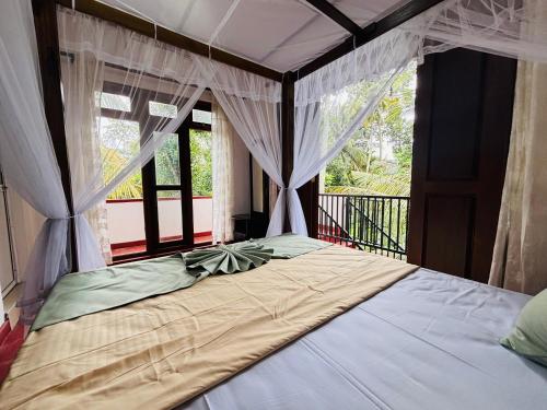 KandyYasasa Spiritual Ayurvedic Villa的一间卧室配有带窗帘的床和窗户