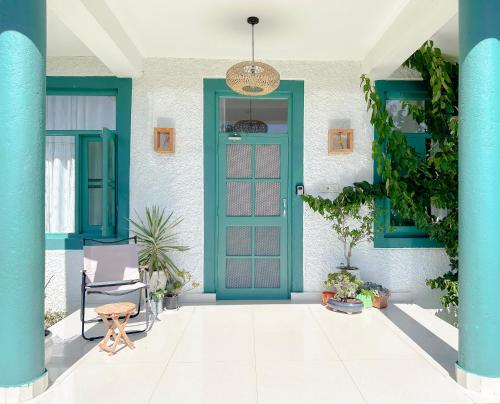 eine blaue Tür auf einem Haus mit Pflanzen in der Unterkunft Cottage Story Bir in Bir