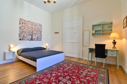 a bedroom with a bed and a desk and a table at Residenza La Donzella - Appartamento bianco in Campobasso