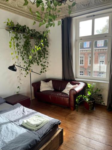 a living room with a couch and a window at Sonniges Zimmer Sternschanze in Hamburg