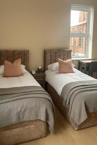 two beds sitting next to each other in a bedroom at Modern Studio Bolton ,Free Parking, Fast WiFi, Ideal for Contractors & Long Stays in Bolton