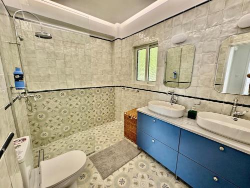 une salle de bain avec toilettes, lavabo et miroir dans l'établissement Poros Thea Villa, à Poros