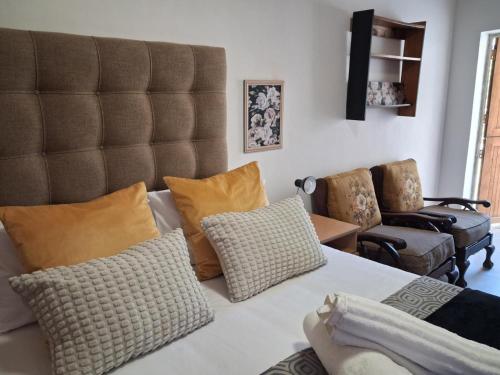 a living room with a large bed with pillows at Juliet Rose Luxury Guesthouse B&B in Bloemfontein