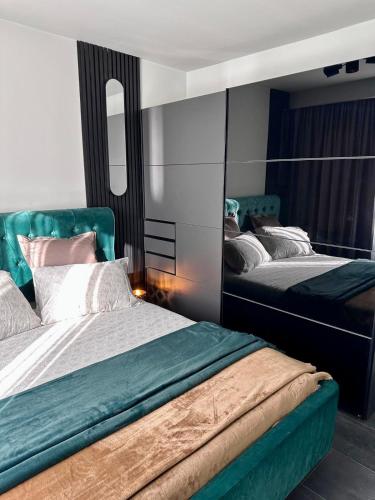 a bedroom with two beds and a mirror at GZP Residence Lugoj in Lugoj
