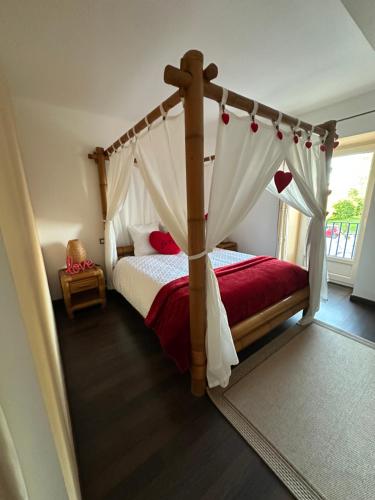 OyréKourline Villalunoterie Futuroscope Piscine spa的一间卧室配有一张木床和天篷