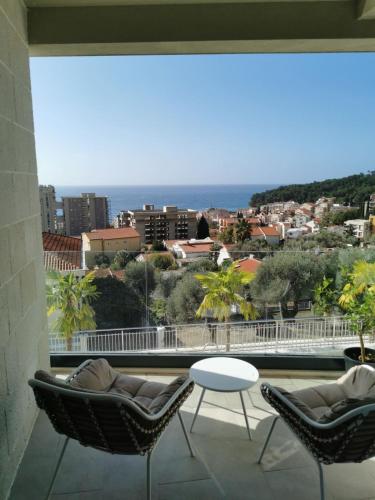 a balcony with chairs and a view of the ocean at Mira apartman Oliva Residence in Petrovac na Moru
