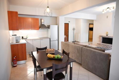 een keuken en woonkamer met een tafel en een bank bij Stellina's Spot in Larisa