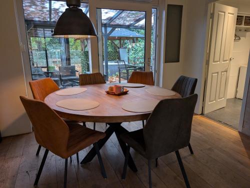a dining room table and chairs in a room at Heerlijk Huisje Heerle
