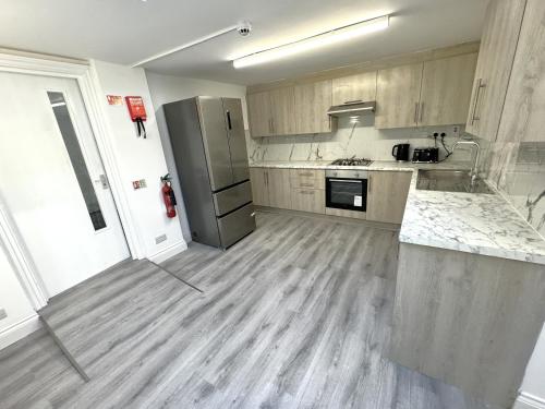 a kitchen with wooden floors and stainless steel appliances at Charming 3 Bed Home Stay in Plumstead
