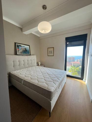 a bedroom with a large bed and a large window at Mira apartman Oliva Residence in Petrovac na Moru