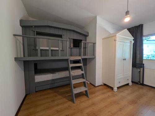 a bedroom with a bunk bed with a ladder at Heerlijk Huisje Heerle 