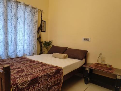 a small bedroom with a bed and a window at Harmonic Hideout in Varkala