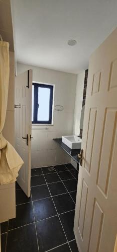 a bathroom with a white door and a black tile floor at Samaya Private Home Panipokhari - 5BHK in Thapathali