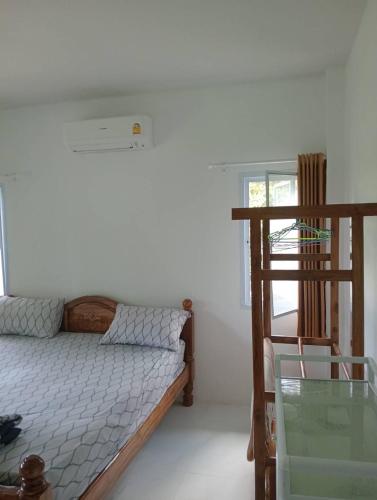 een slaapkamer met een bed en een glazen tafel bij Silva Haus in Ban Nua