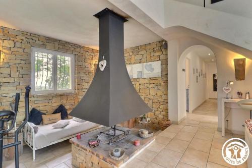 un piano cottura in un soggiorno con parete in pietra di Le Loft de la garrigue a Cadolive