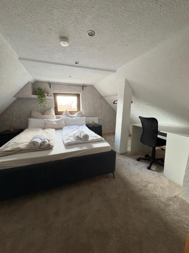 a bedroom with a large bed and a desk at Small House park free at street in Stuttgart