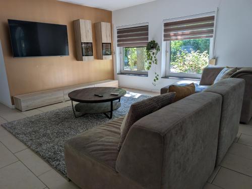 a living room with a couch and a table at Heerlijk Huisje Heerle