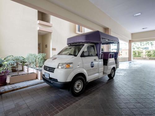a white golf cart parked in a building at Grand Mercure Bangkok Asoke Residence in Bangkok