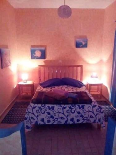 a bedroom with a bed and two lamps on two tables at Djabraba's Double Suite in Garça