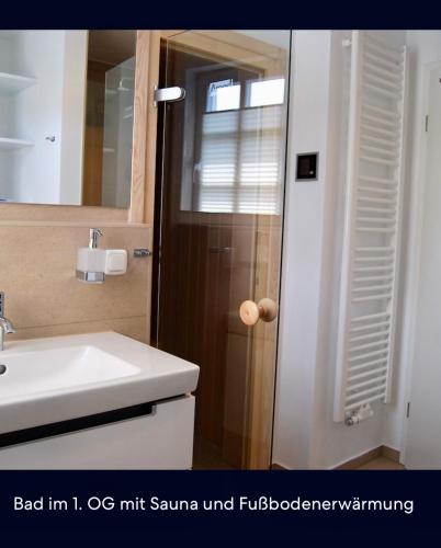 a bathroom with a sink and a toilet and a mirror at Claras Strandhuus in Zingst