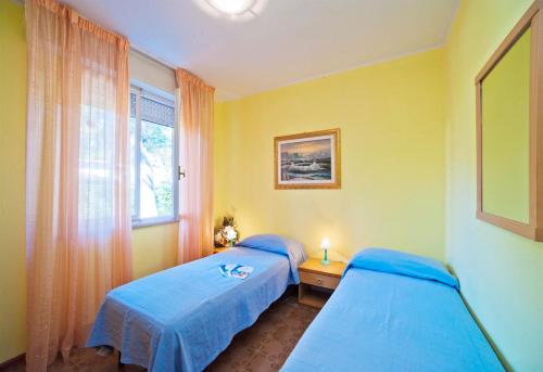 two beds in a room with a window at Olimpia in Bibione