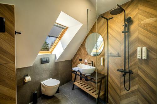 a bathroom with a skylight and a toilet and a sink at Acacia Hotel in Sofia