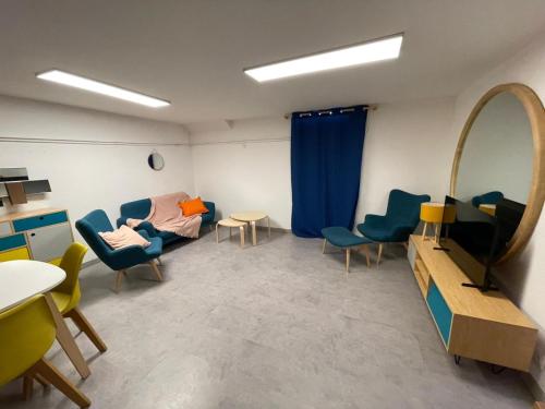 a room with a couch and chairs and a mirror at Underground appart in Saint-Sébastien-sur-Loire