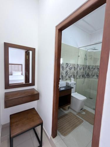 a bathroom with a mirror and a sink and a toilet at The Altura Apartment in Mount Lavinia