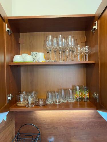 un mucchio di bicchieri sono su uno scaffale di Vesta Boutique Apartment a Bansko