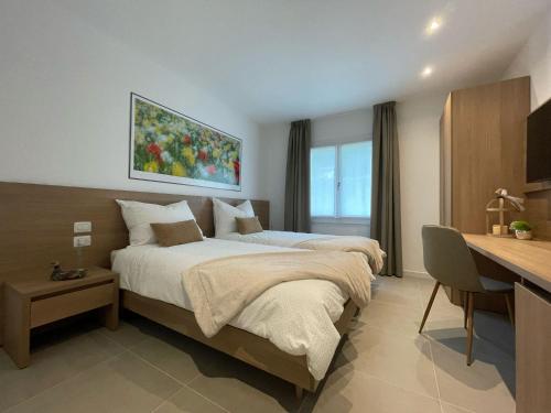 a hotel room with two beds and a desk with a computer at LA MUELE Affittacamere in Gemona del Friuli
