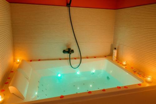 a bath tub with a shower in a room at Gîte avec jacuzzi pour 14 personnes, lacs, vignobles proche Kaysersberg in Lapoutroie