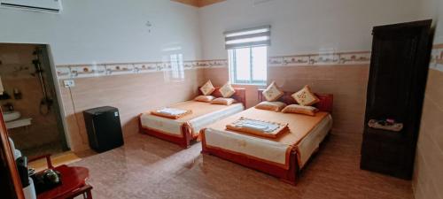 a bedroom with two beds and a television in it at Van tan in Kon Plong