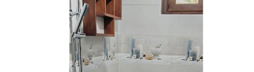 two pictures of a bathroom with vases on the wall at Ariyana Sky Suites in Matara