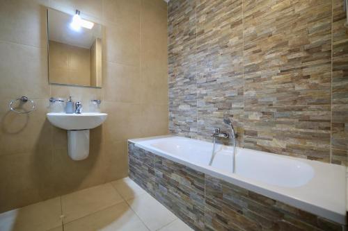 a bathroom with a bath tub and a sink at Central 2 Bed Apartment in Gwardamanġa