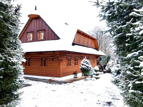 a log cabin with snow on the roof at Liptovská Drevenica in Liptovský Mikuláš