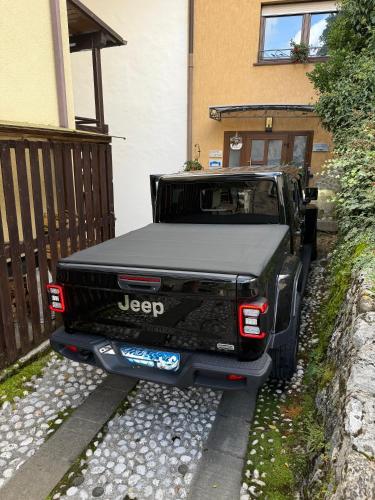 a black truck parked in front of a house at Apartma na klancu in Kobarid