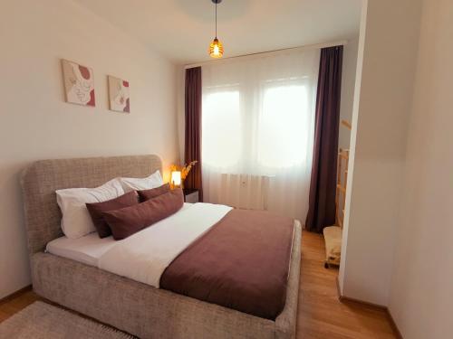 a bedroom with a bed and a large window at Aria Apartment in Pristina