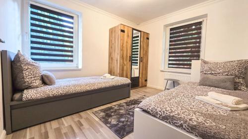 a bedroom with a bed and two windows with blinds at 90m Apartment 5 Schlafplätze in Tostedt
