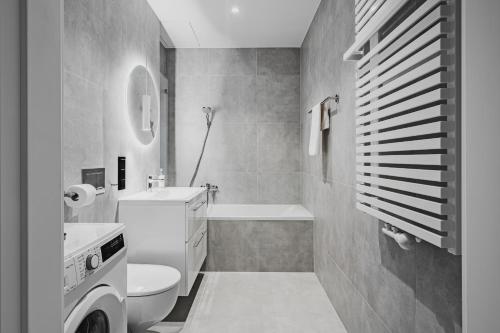 a bathroom with a toilet and a sink and a tub at Towarowa Towers SkyLine View in Warsaw