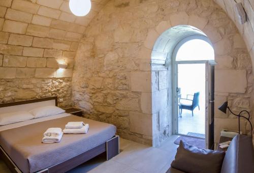 una camera con un letto in una parete in pietra di B&B Vista Iblea a Ragusa