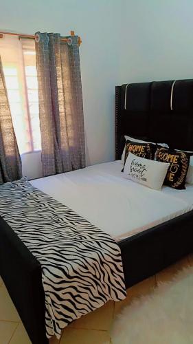 a zebra print bed in a room with a window at Zion Apartment Diani in Diani Beach