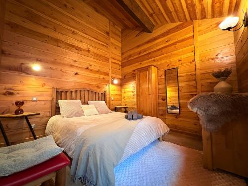een slaapkamer met een bed in een houten hut bij Le Douillet des Pyrénées, Luxury Chalet Home in Ax-les-Thermes