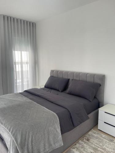 TiraneThe 5 Maji Escape的一间卧室配有一张大床和灰色的床罩
