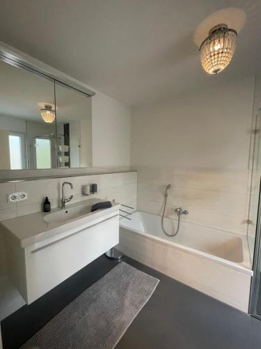 a bathroom with a tub and a sink and a mirror at Sylvis Home Zentral gelegenes Ferienhaus in ruhiger Lage in Fürth