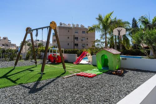 a playground with a swing and a play set at Pearl Beach Luxury Family Suite in Limassol